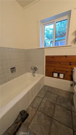 a bathroom with a double vanity sink a toilet a mirror and bathtub