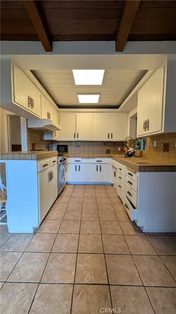 a large kitchen with stainless steel appliances granite countertop a stove a sink dishwasher and a refrigerator