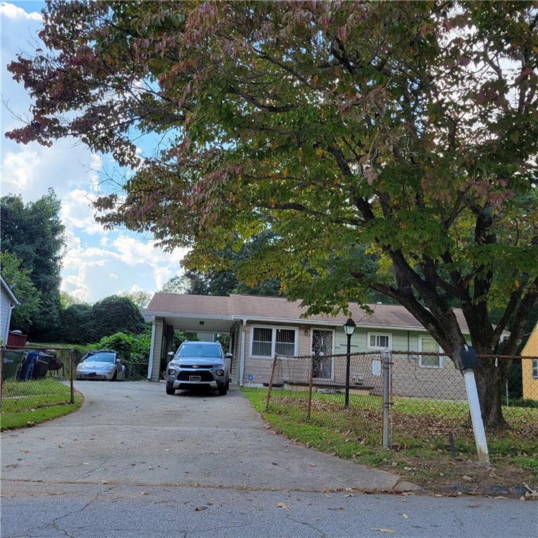 856 Margaret Place Northwest Atlanta, GA 30318 - Photo 1 of 1 a car parked in front of a house next to a yard