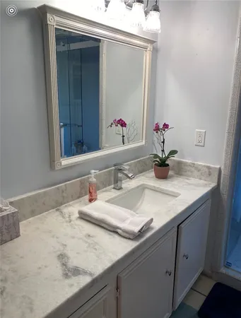 a bathroom with a granite countertop sink and a mirror