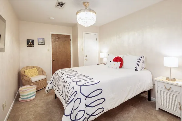 a bedroom with a bed and a chandelier