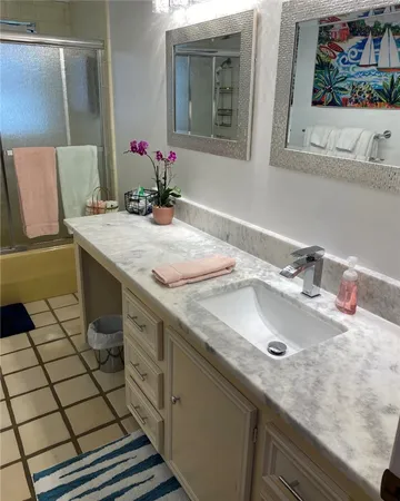 a bathroom with a granite countertop sink and a mirror