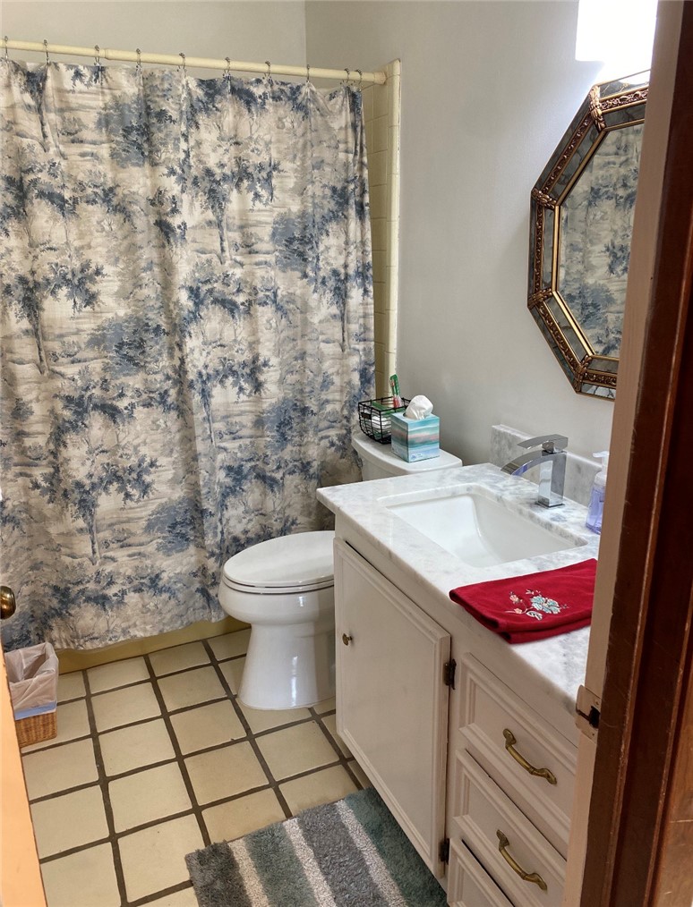 2902 Chaparral Circle Bryan, TX 77802 - Photo 26 of 26 a bathroom with a granite countertop toilet a sink and a mirror
