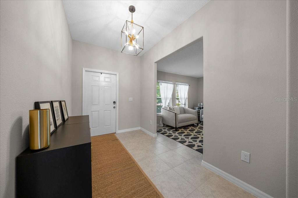 9329 Southwest 57th Terrace Ocala, FL 34476 - Photo 5 of 64 a bedroom with a bed and a chandelier
