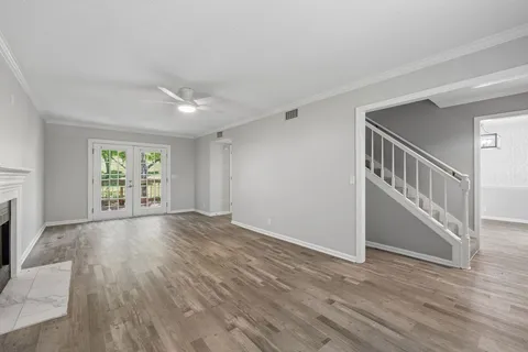 a view of empty room with wooden floor and fireplace
