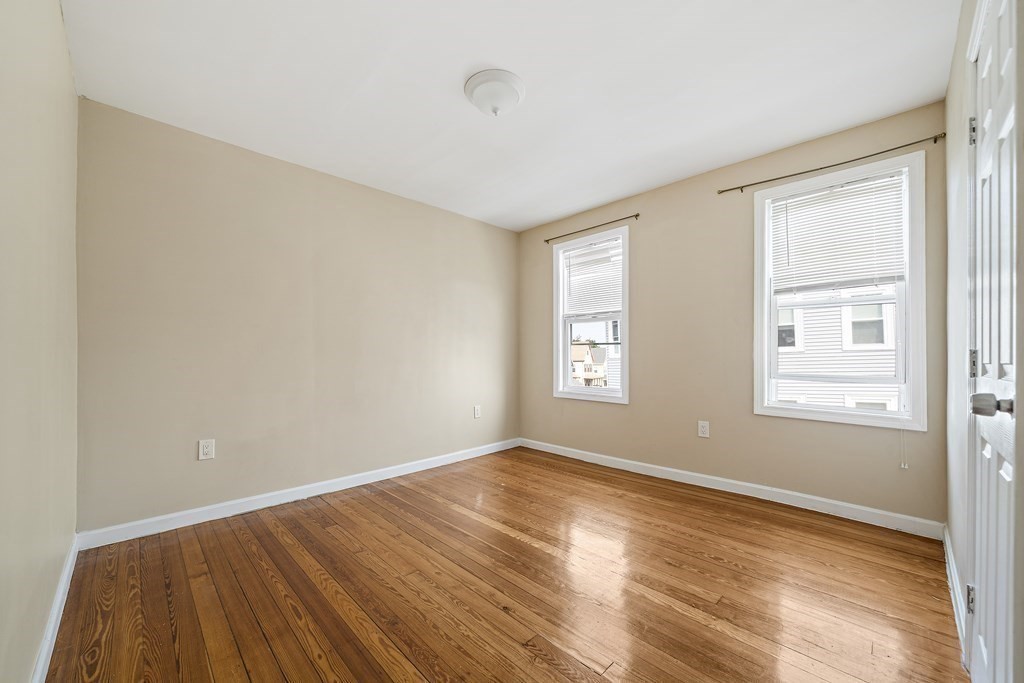 7 Tolman Street, Unit 3 Boston, MA 02122 - Photo 5 of 12 an empty room with wooden floor and windows