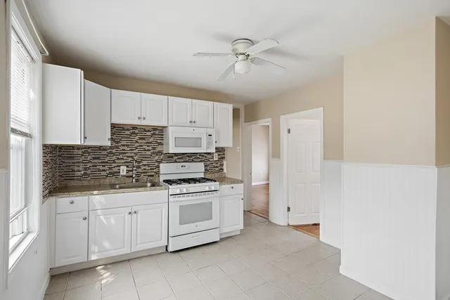 a kitchen with white cabinets and white appliances