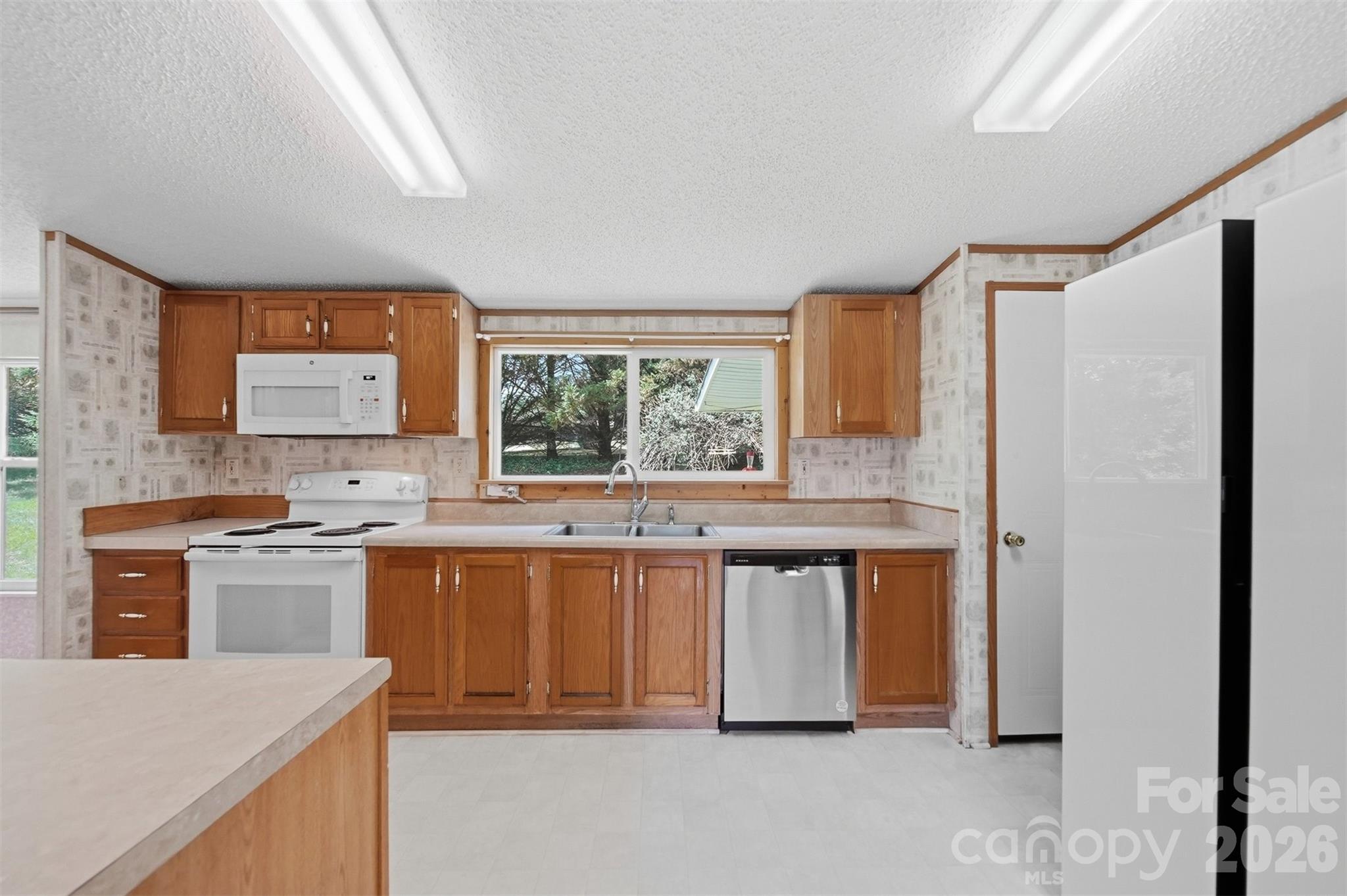 1488 Watermill Road Morganton, NC 28655 - Photo 14 of 38 a kitchen with stainless steel appliances granite countertop a stove a sink and a refrigerator