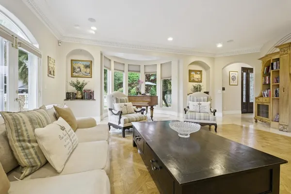 a living room with couches and kitchen view with wooden floor