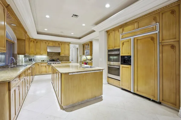 a kitchen with stainless steel appliances granite countertop a stove a sink and a refrigerator