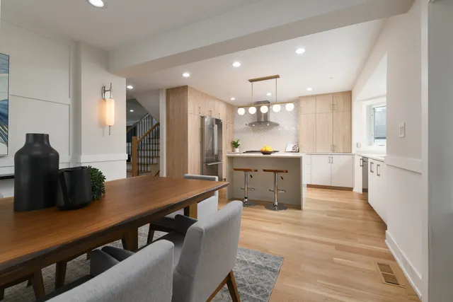 a kitchen with stainless steel appliances kitchen island granite countertop a sink a stove a dining table and chairs