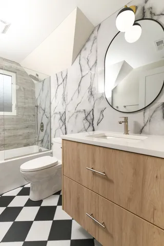 a bathroom with a toilet a sink and mirror