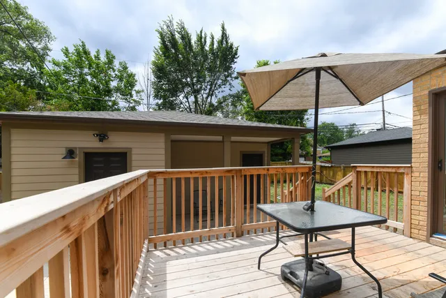 a roof deck with table and chairs under an umbrella