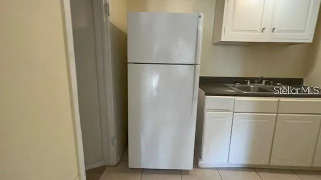 a white refrigerator freezer and a stove sitting inside of a kitchen