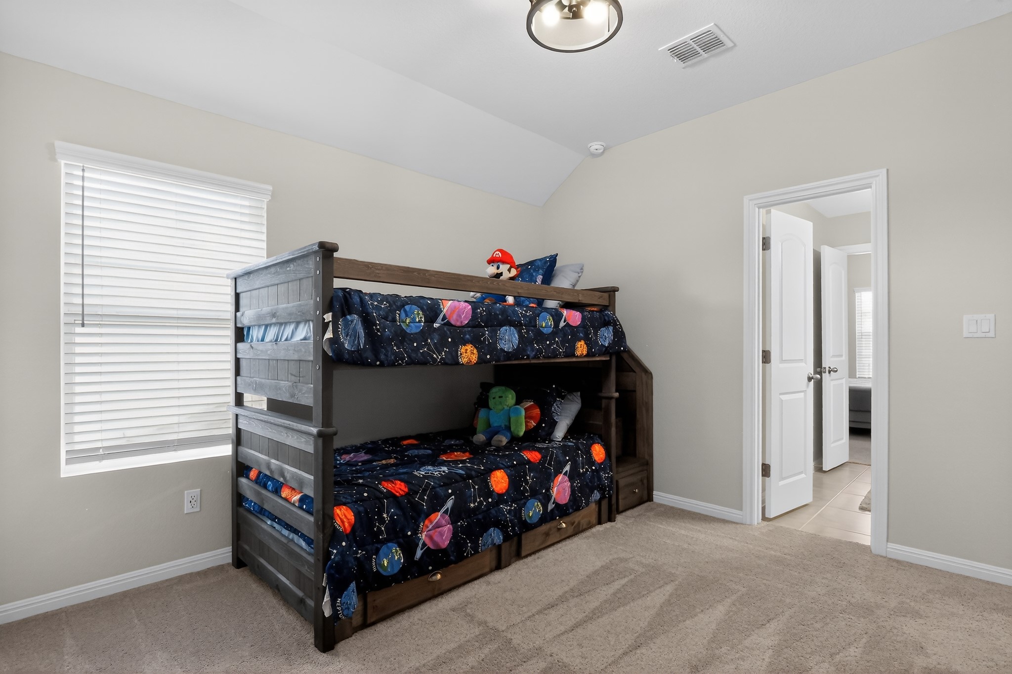 114 Bosco Road Hutto, TX 78634 - Photo 29 of 39 A comfortable bedroom features plush carpeting and a practical bunk bed with built-in storage drawers, ideal for a growing family.