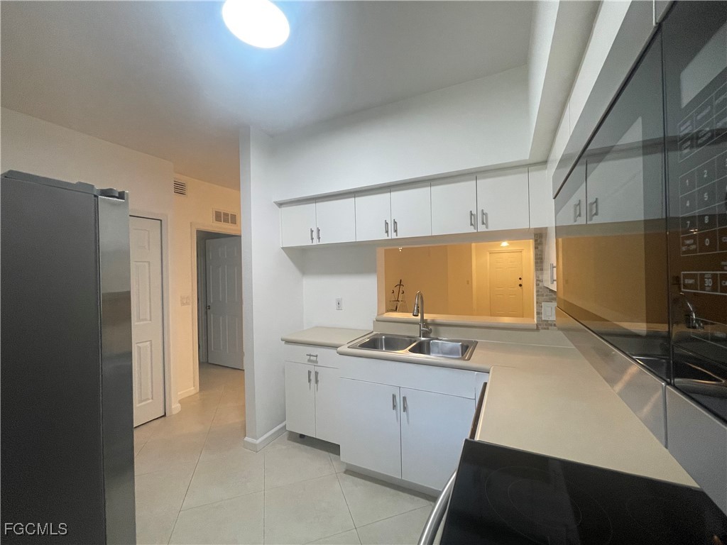 8416 Bernwood Cove Loop, Unit 1611 Fort Myers, FL 33966 - Photo 38 of 50 a kitchen with stainless steel appliances a refrigerator a sink and a stove