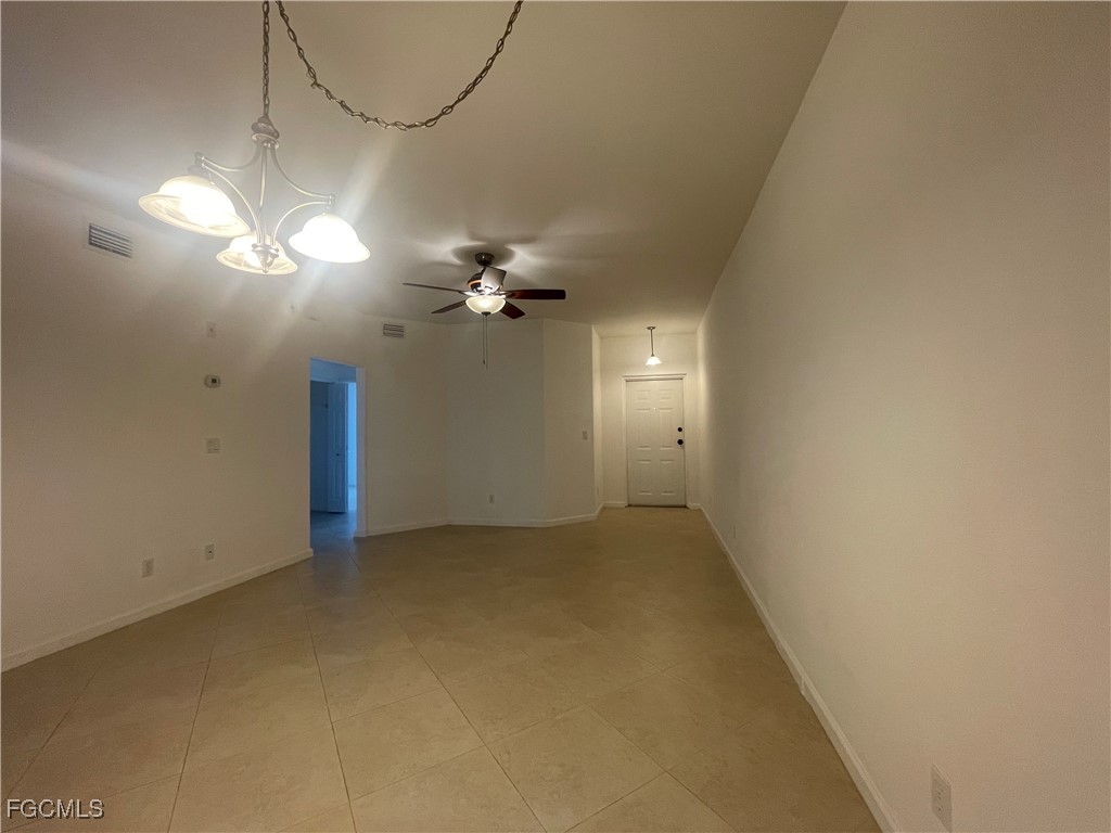 8416 Bernwood Cove Loop, Unit 1611 Fort Myers, FL 33966 - Photo 9 of 50 an empty room with a chandelier fan and windows