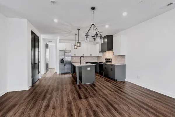 a view of a hallway with wooden floor and entryway