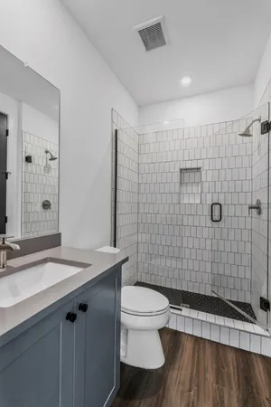 a bathroom with a sink a toilet and shower