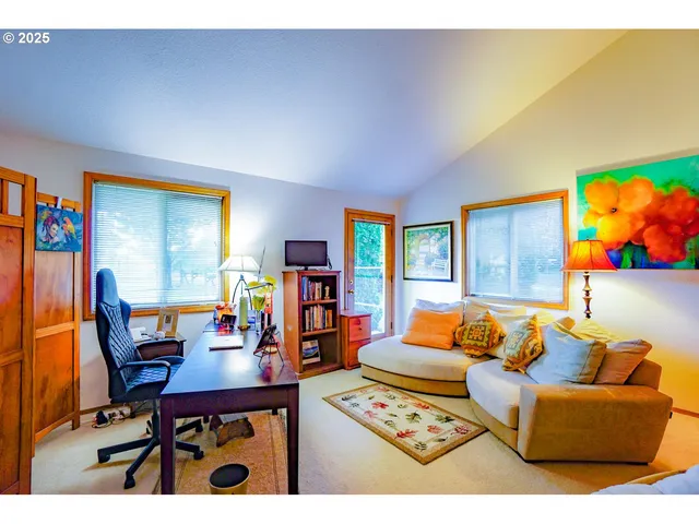 a living room with furniture a rug and a wall painting