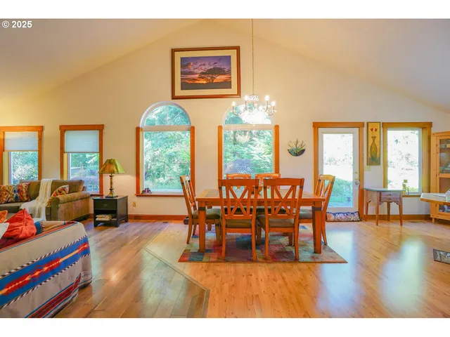 a dining room with furniture a chandelier and wooden floor