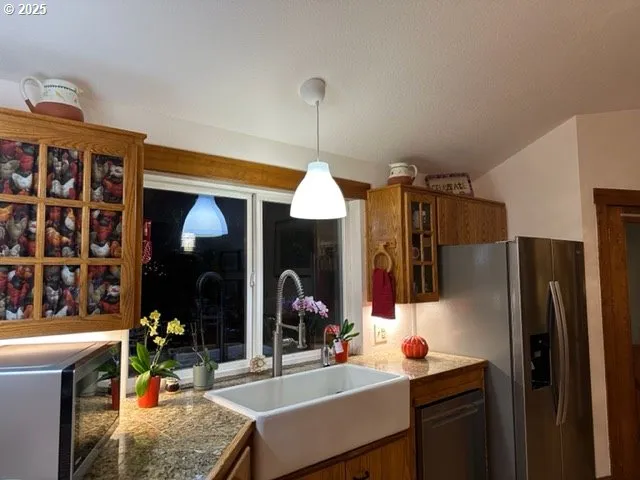 a kitchen with a sink dishwasher a refrigerator and a dining table with wooden floor