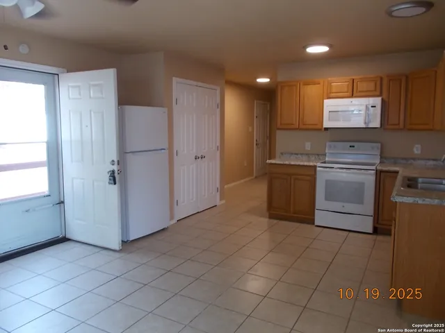 a kitchen with stainless steel appliances granite countertop a refrigerator and a stove