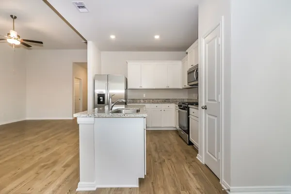a kitchen with kitchen island a sink appliances and cabinets