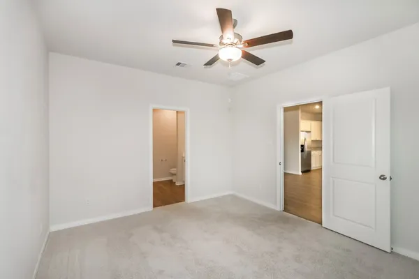 an empty room with closet and fan