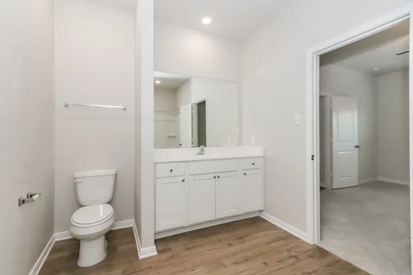 a spacious bathroom with a toilet sink and mirror