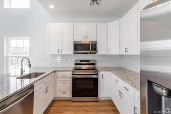 a kitchen with stainless steel appliances granite countertop a stove and a sink