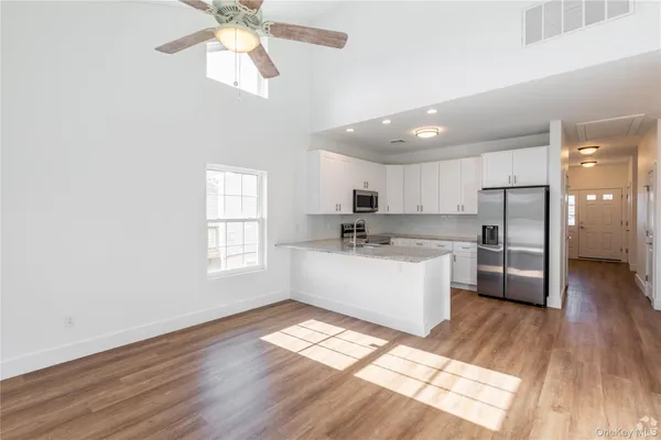 a kitchen with stainless steel appliances a refrigerator a sink dishwasher with a oven and wooden floor