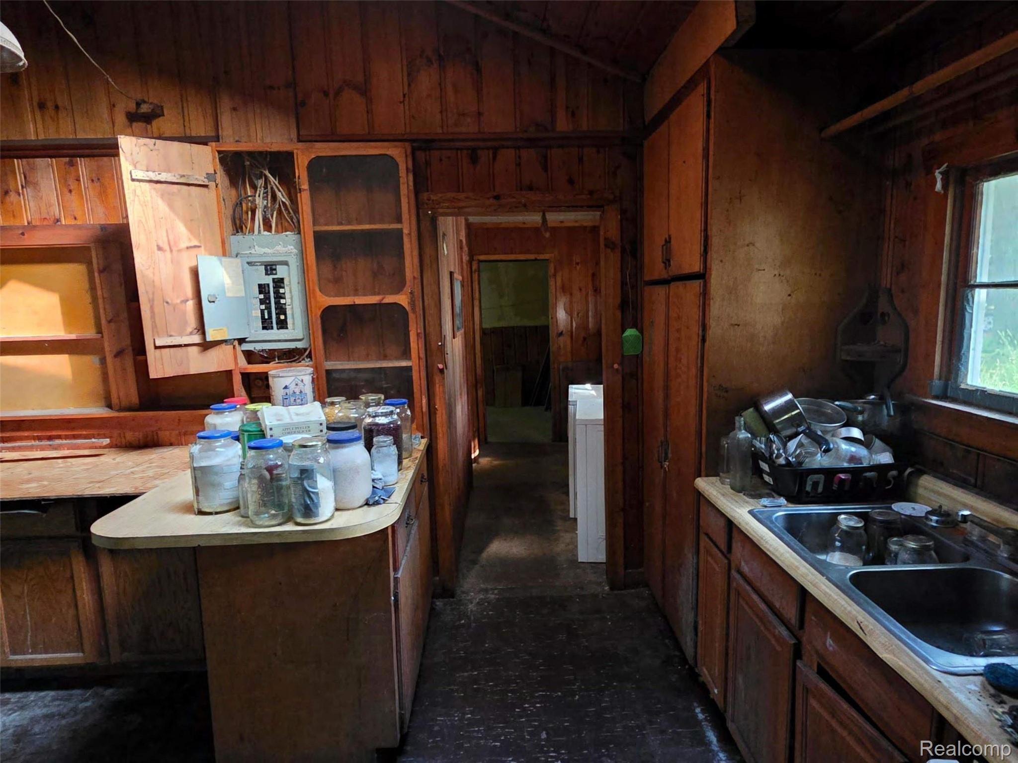 5420 Randy Drive Prescott, MI 48756 - Photo 23 of 31 Wood-paneled interior featuring extensive cabinetry and a built-in sink