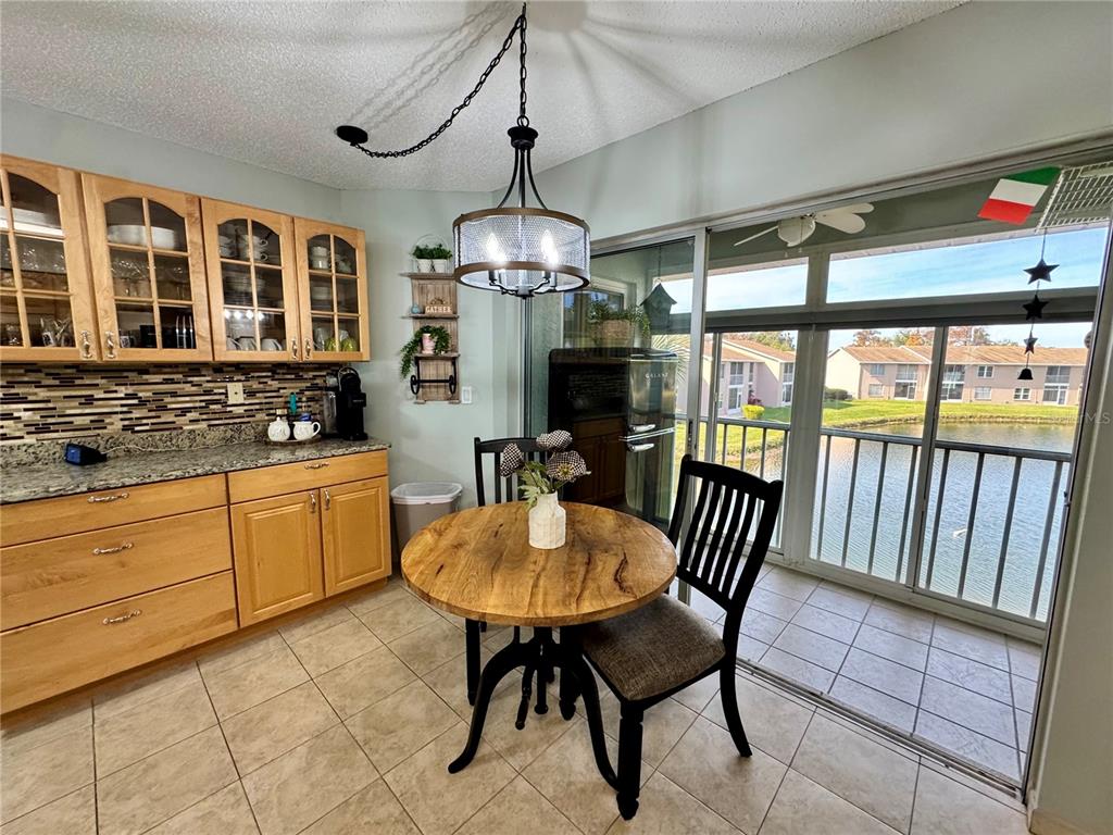 6527 Spring Flower Drive, Unit 21 New Port Richey, FL 34653 - Photo 11 of 21 a kitchen with stainless steel appliances granite countertop a stove a refrigerator a dining table and chairs with wooden floor