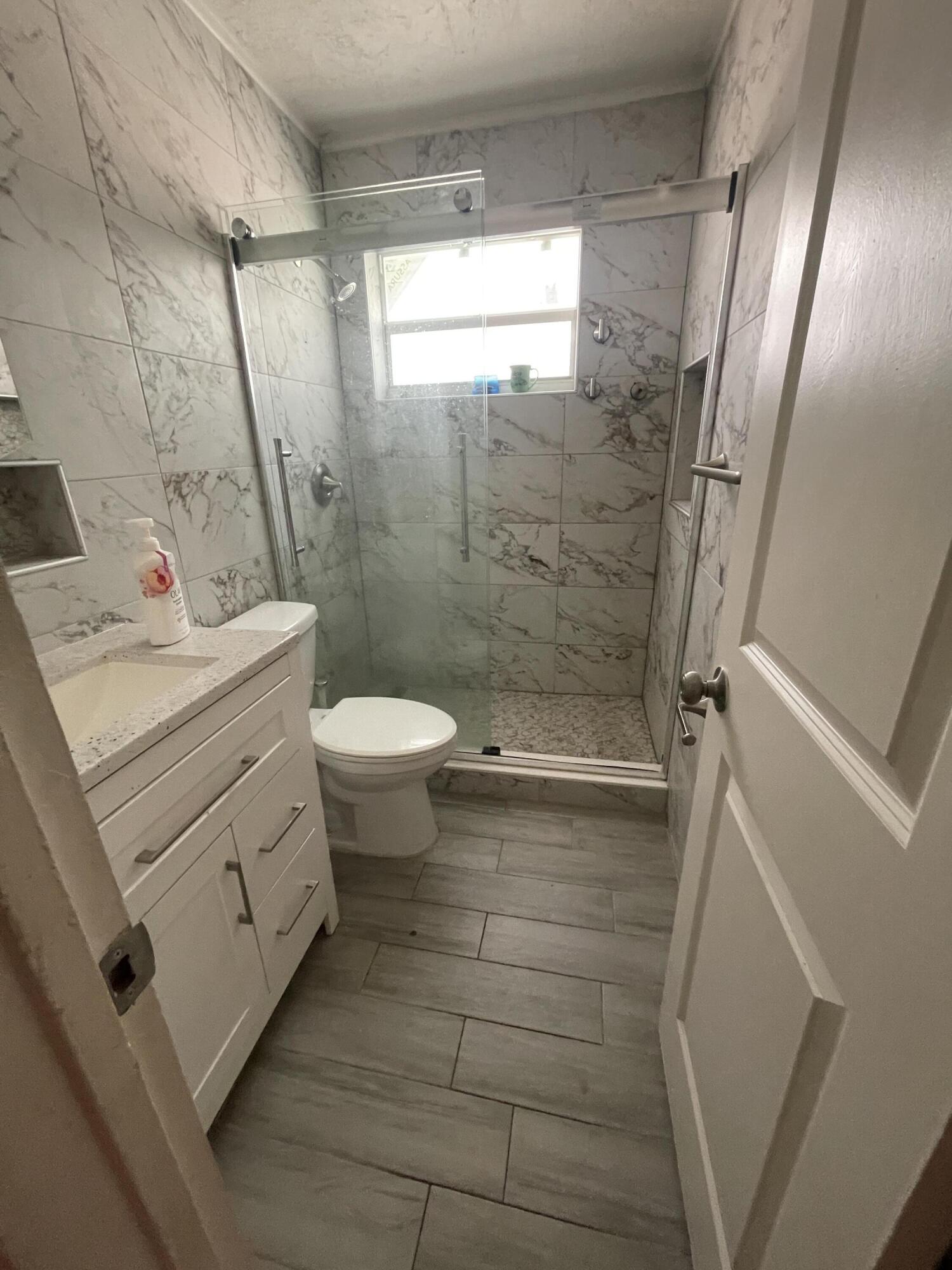 113 Northeast 5th Avenue Boynton Beach, FL 33435 - Photo 11 of 14 a bathroom with a sink a toilet and shower