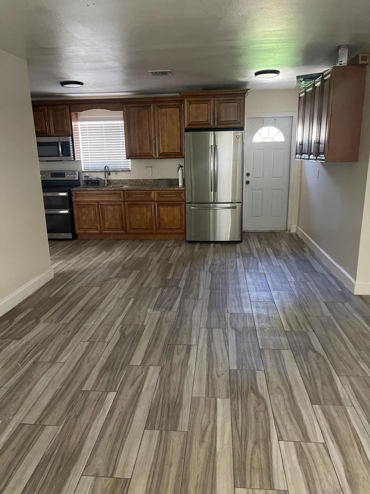 113 Northeast 5th Avenue Boynton Beach, FL 33435 - Photo 3 of 14 a kitchen with stainless steel appliances granite countertop a refrigerator a sink and wooden cabinets