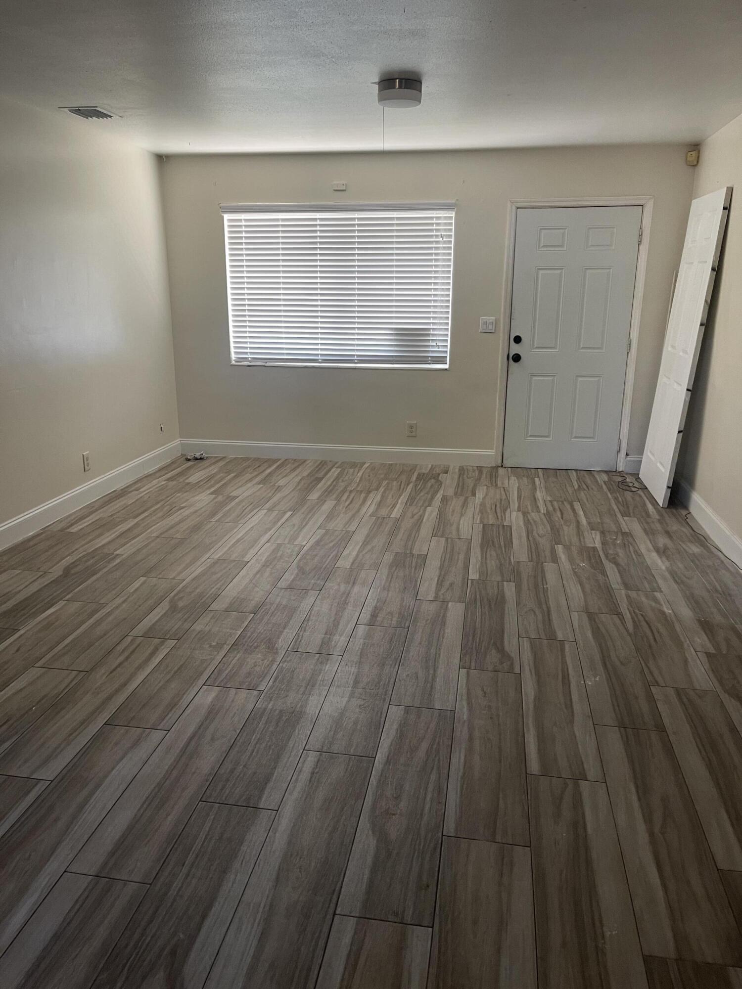 113 Northeast 5th Avenue Boynton Beach, FL 33435 - Photo 8 of 14 an empty room with wooden floor and windows