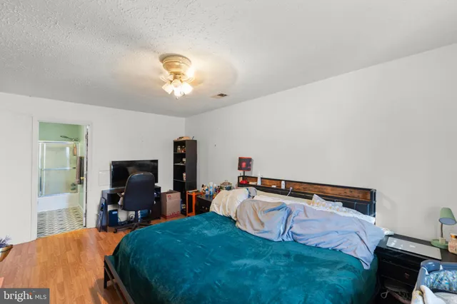 a bedroom with a bed and a flat tv screen on dresser