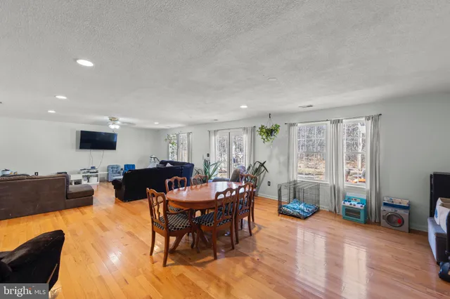 a living room with furniture a flat screen tv and a large window