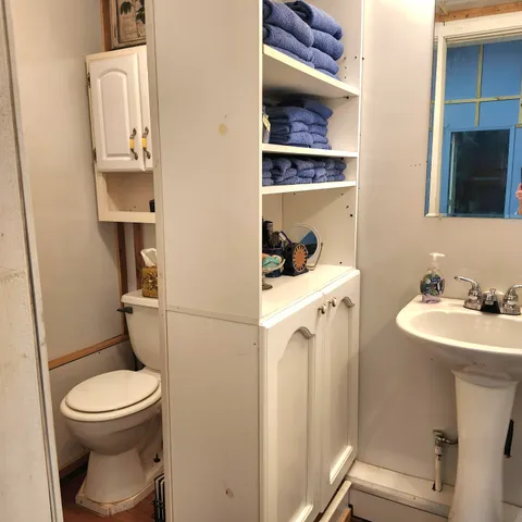 a bathroom with a toilet sink and mirror