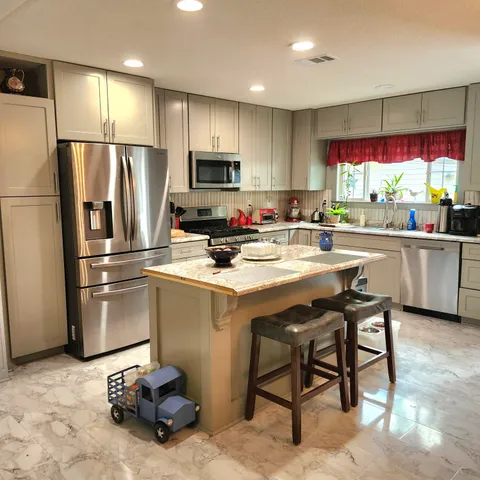 a kitchen with refrigerator cabinets and a large window