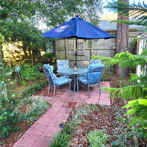 a view of a patio with table and chairs under an umbrella