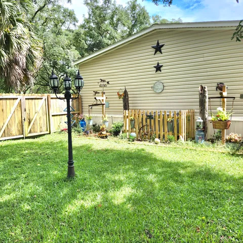 a view of a house with backyard and a tree