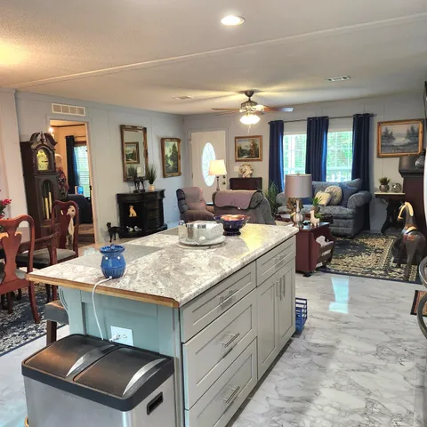a view of a deck with large trees and wooden fence