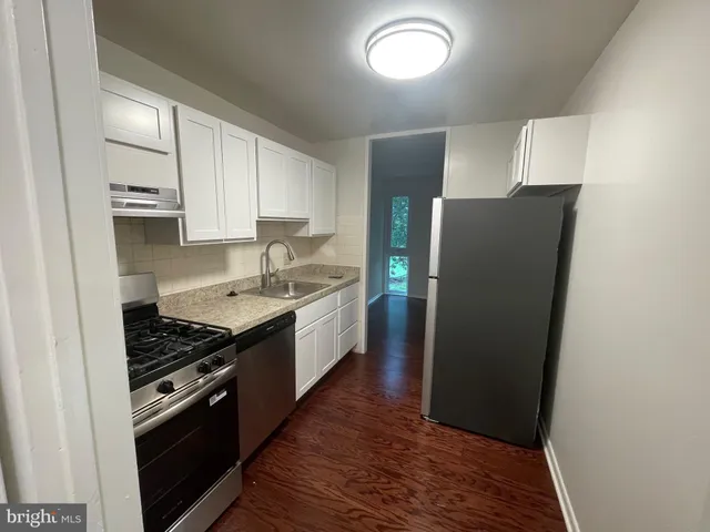 a kitchen with stainless steel appliances granite countertop a stove a refrigerator and a sink