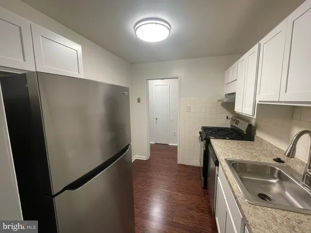 a kitchen with a sink a refrigerator and cabinets