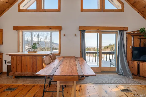 a living room with a couch wooden floor and a large window