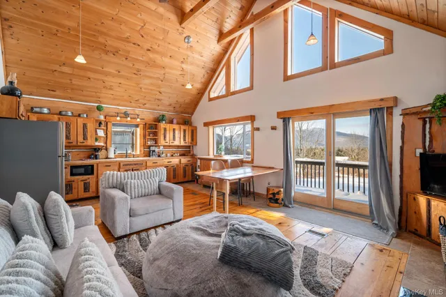 a living room with furniture a flat screen tv and floor to ceiling window