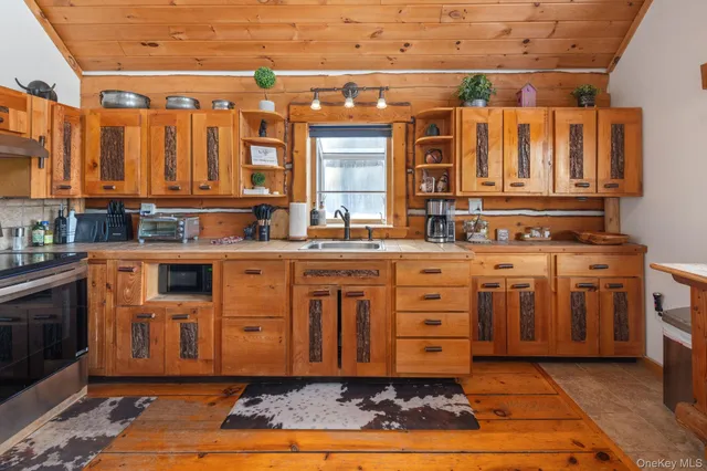a kitchen with stainless steel appliances granite countertop a sink a stove and cabinets