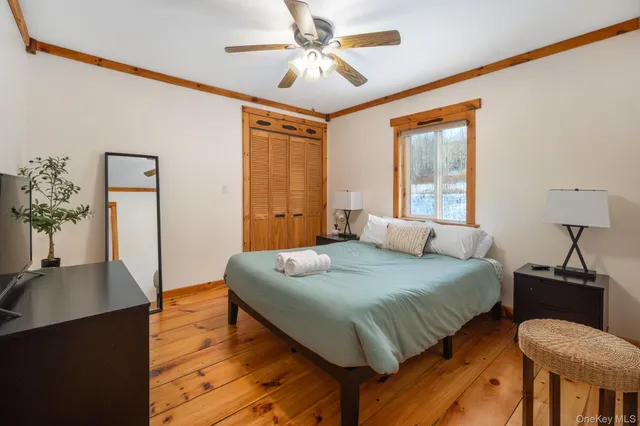 a bedroom with a bed and wooden floor